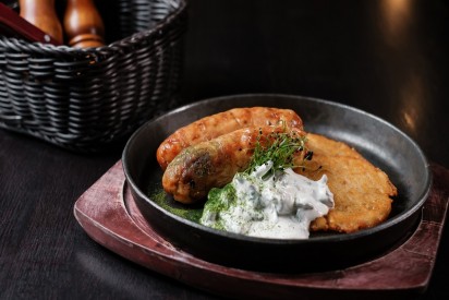 Chicken sausages with potato pancakes and chanterelles in cold  sour cream